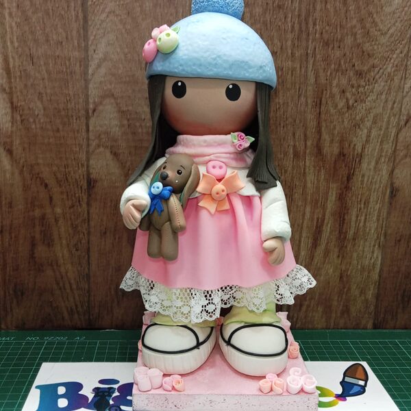 Muñeca de invierno — Muñeca con gorro y abrigo, detalle decorativo.